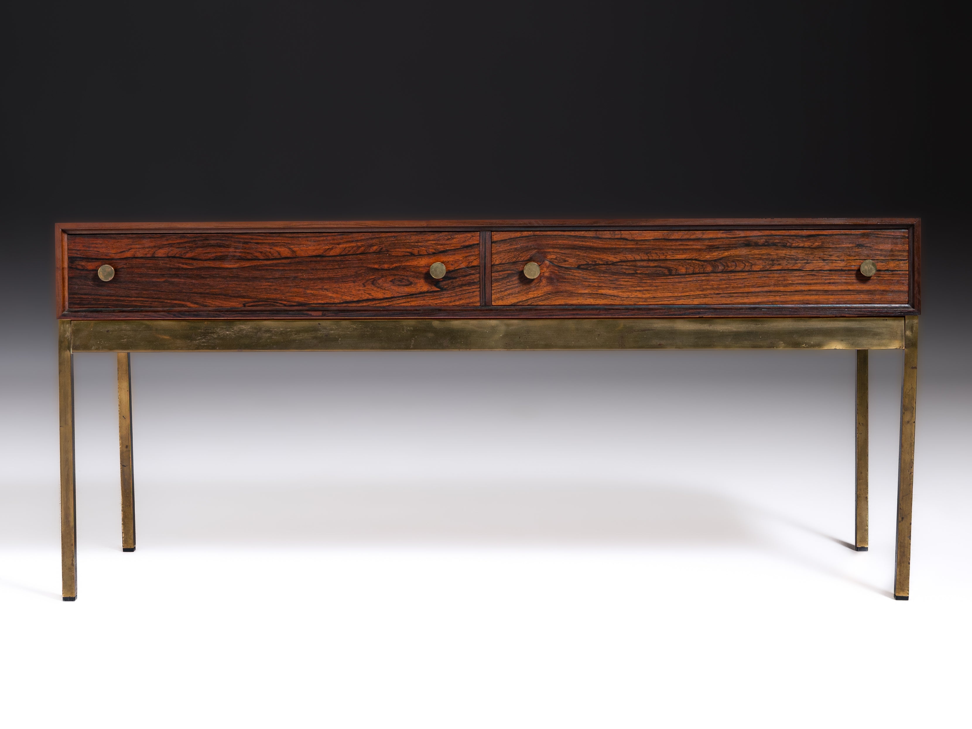 Mesa com duas gavetas em pau-santo e base em latão. Design de Alf Svensson & Yngvar Sandström Fabricante: Nybro