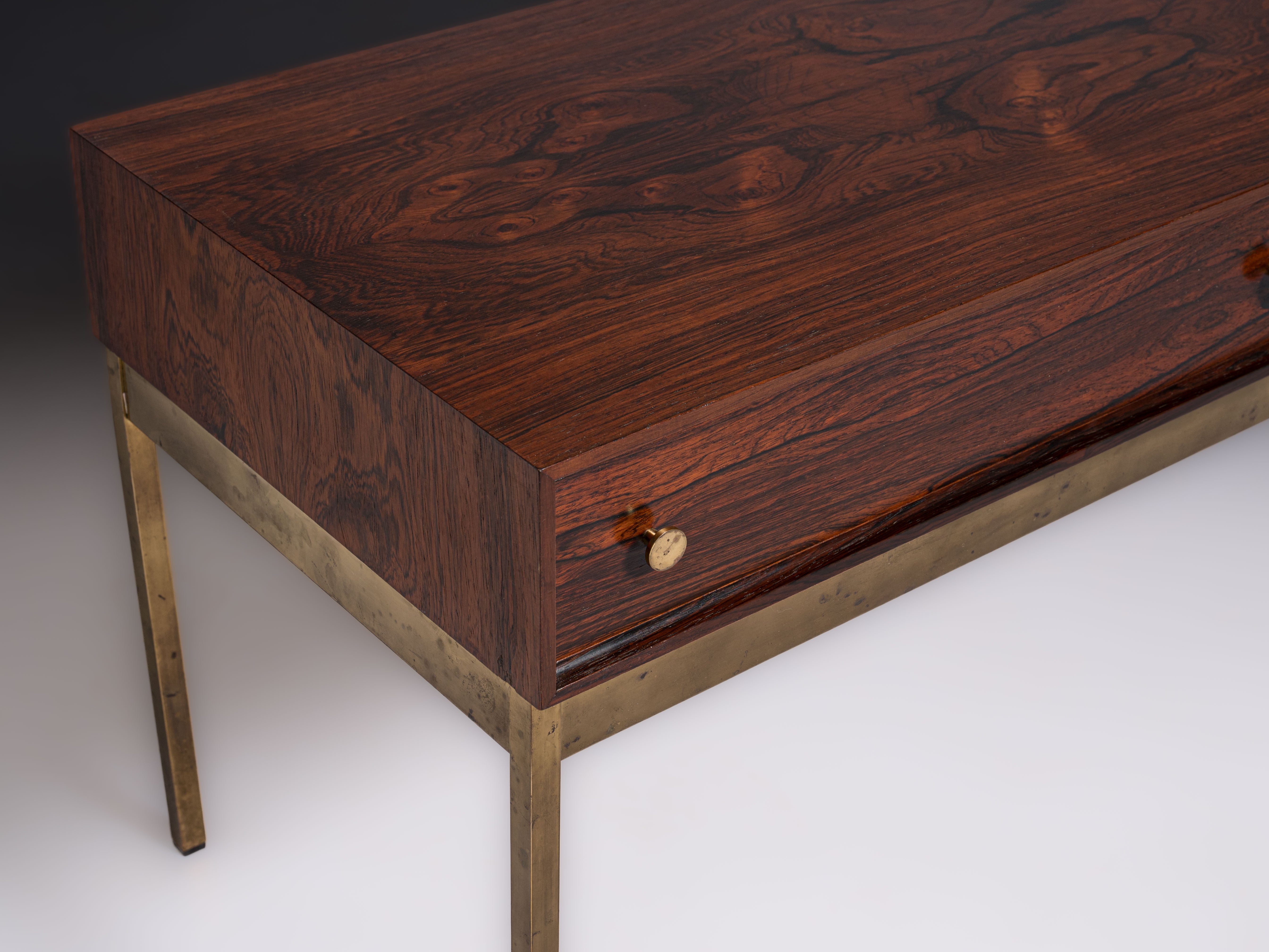 Mesa com duas gavetas em pau-santo e base em latão. Design de Alf Svensson & Yngvar Sandström Fabricante: Nybro