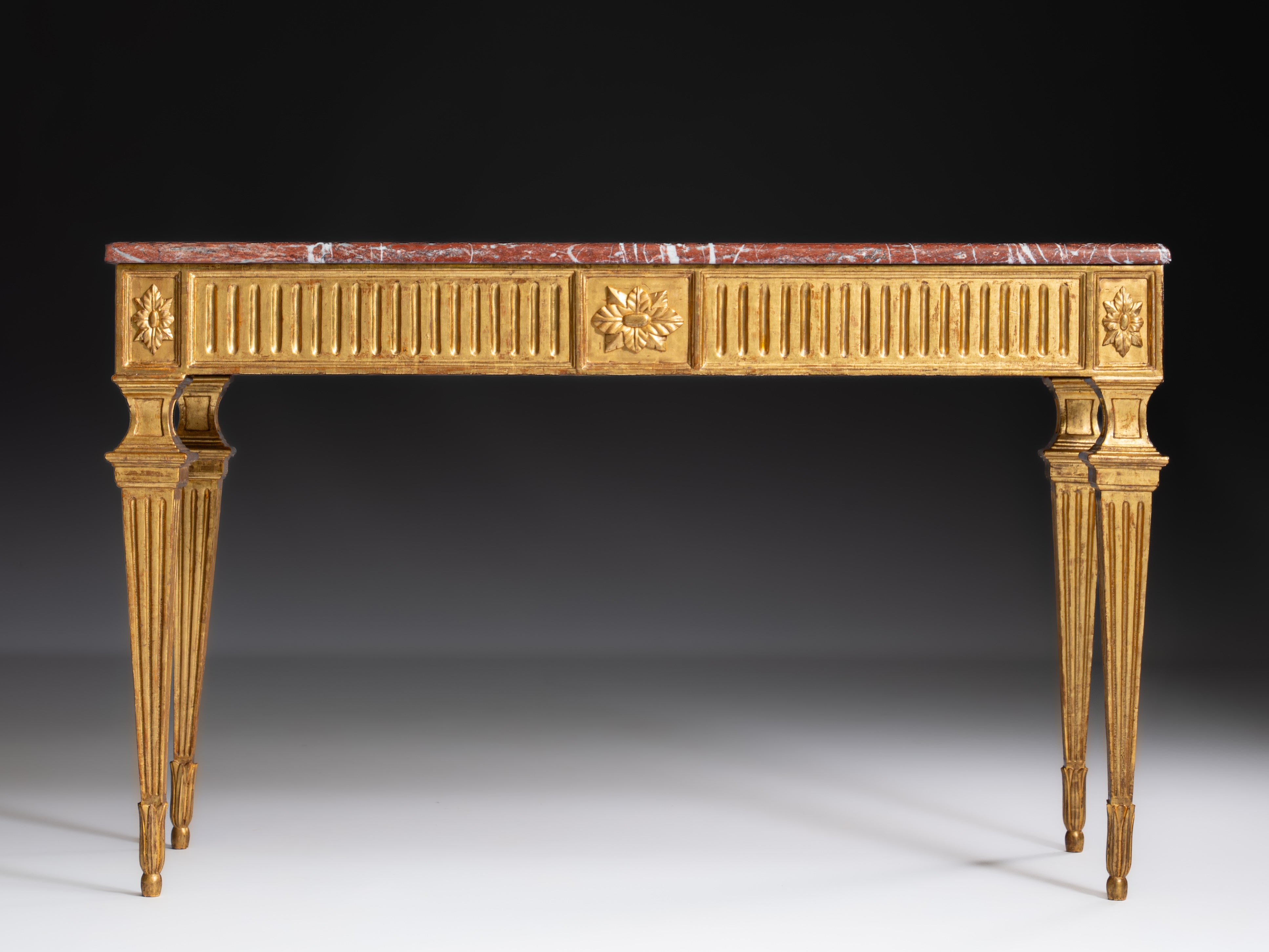 Italian console table in fine gold-gilded wood with a red marble top. Italy, 18th century