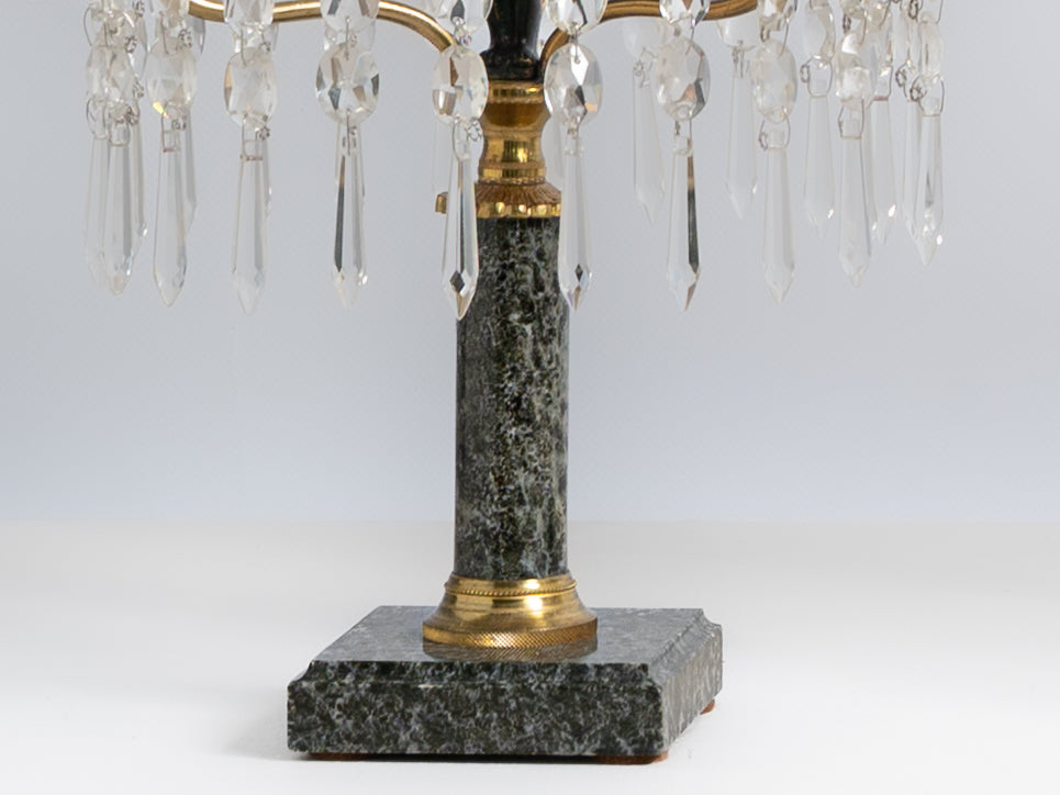 Par de girandoles de 3 lumes em metal dourado, vidro e cristal. Fustes decorados com “putto” e base em mármore. Séc. XIX