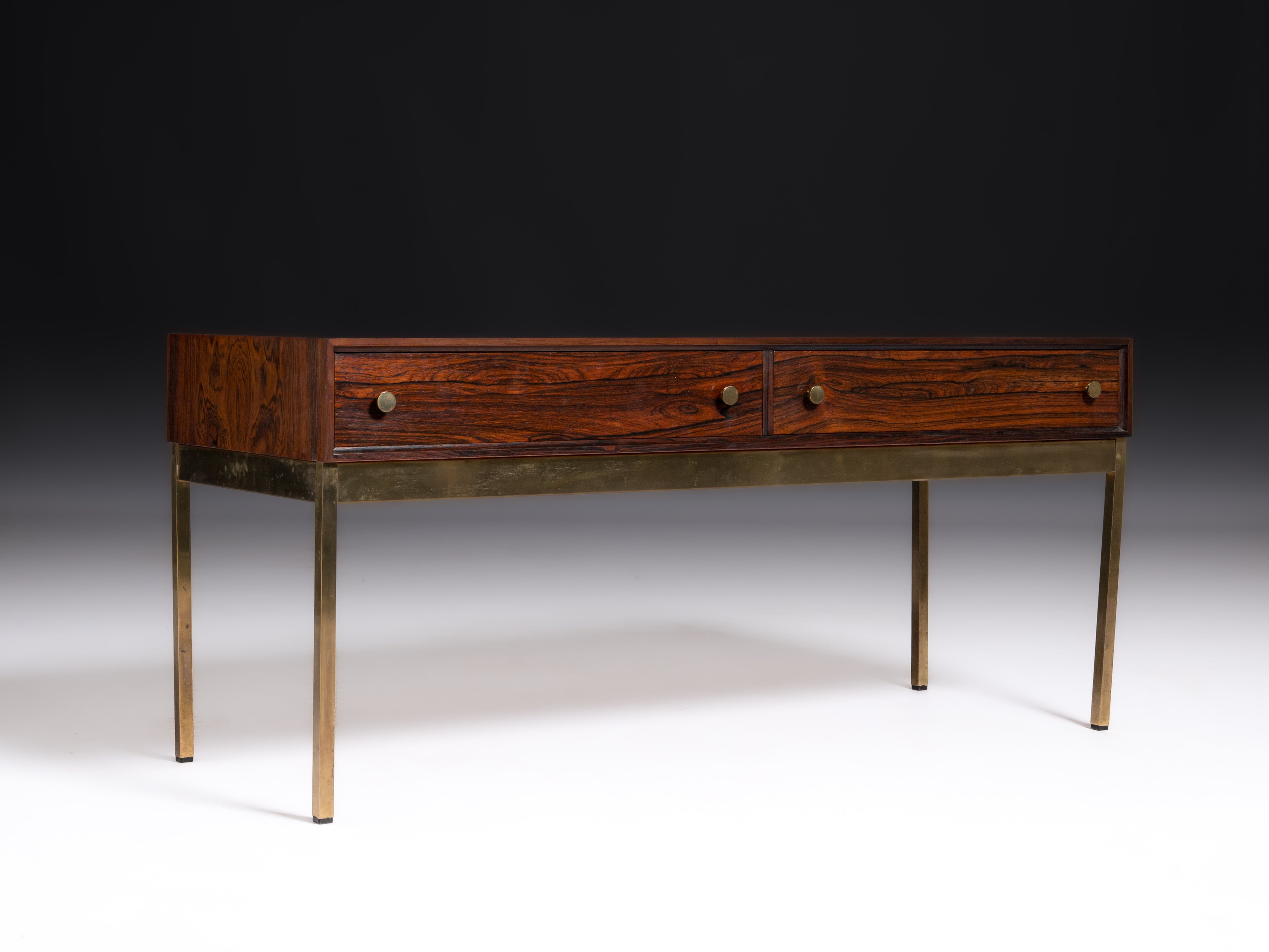 Mesa com duas gavetas em pau-santo e base em latão. Design de Alf Svensson & Yngvar Sandström Fabricante: Nybro